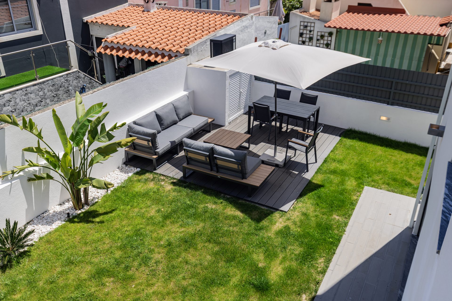 Garden with outdoor lounge, dining area and palms seen from above