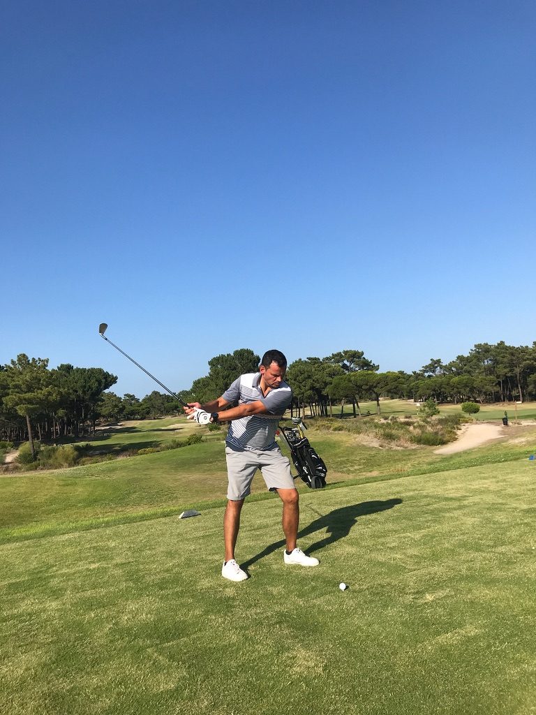 Golfer on the fairway among pines