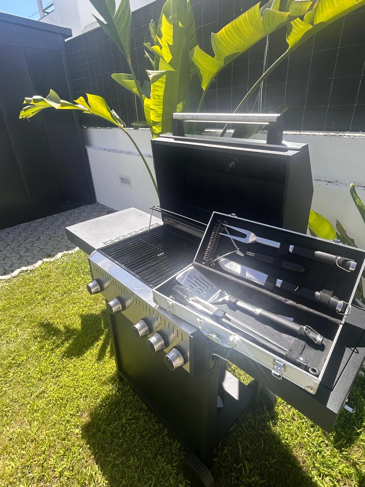 Gas barbecue grill with grill tool set in the garden