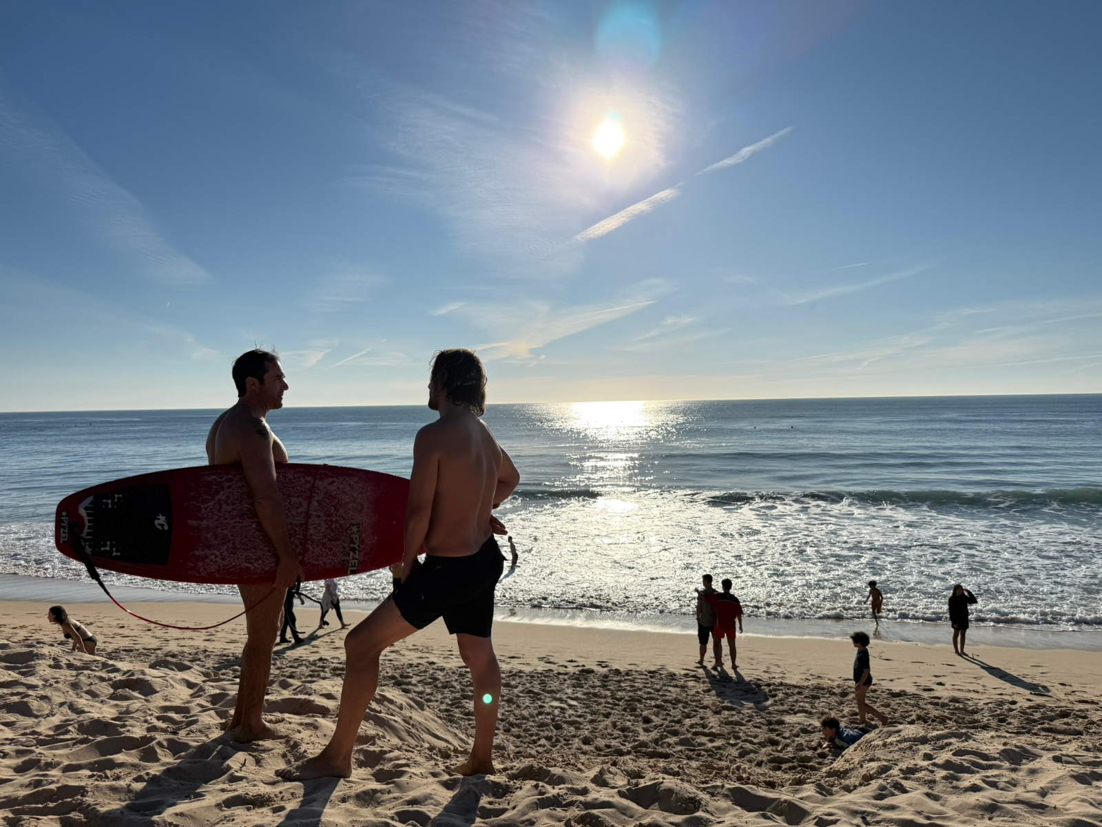 Surfers heading into the Atlantic at Costa da Caparica